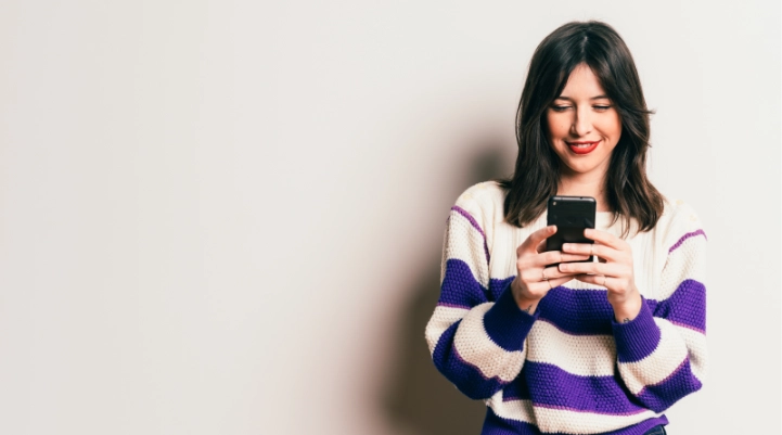 Woman looking at phone while using Zelle