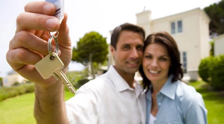 Man and woman smiling and holding house key