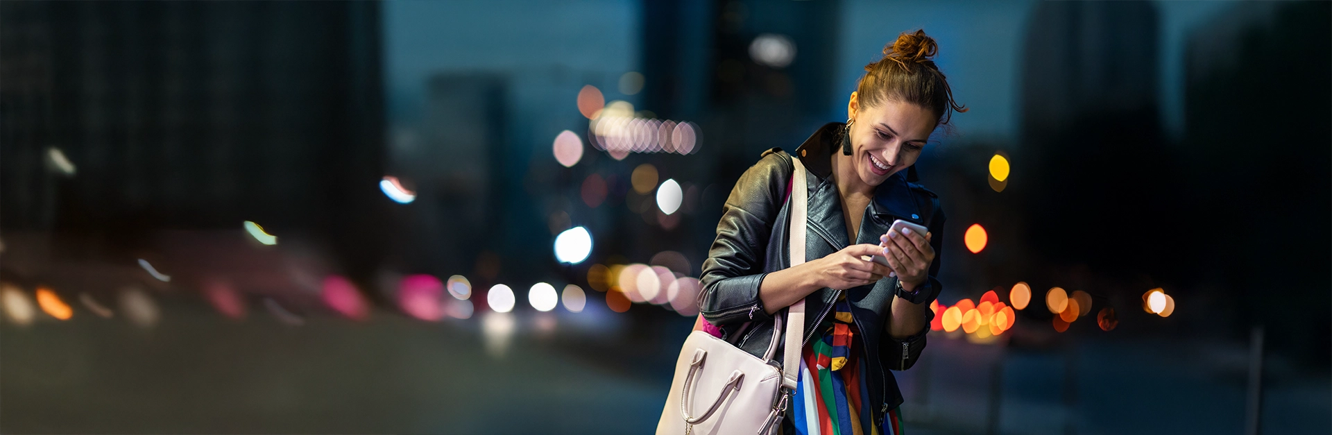 City woman looking at cell phone and smiling